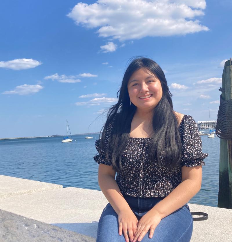 A girl sitting in front of the Atlantic Ocean.