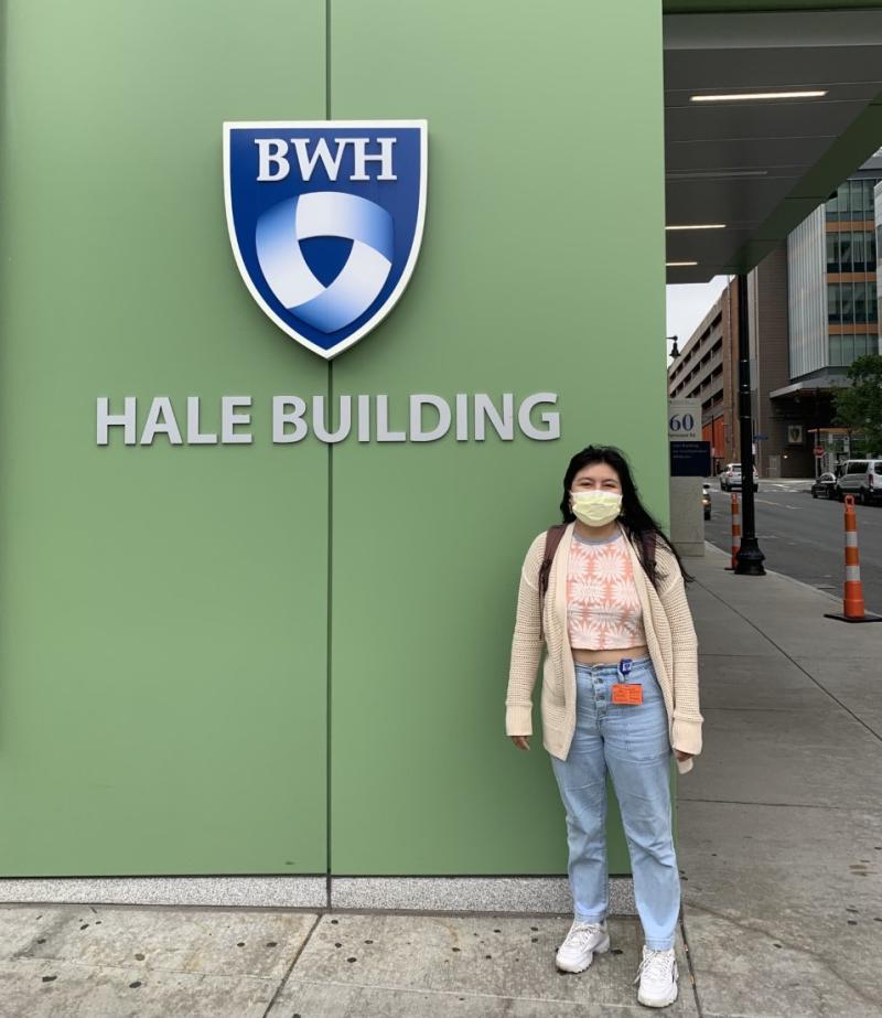 A girl standing outside a building wall that says "BWH Hale Building."