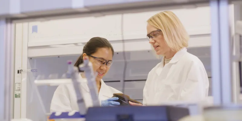 student and mentor looking at object in research lab