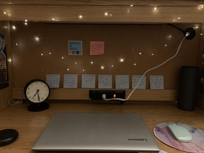 A desk decorated with lights and motivational quotes