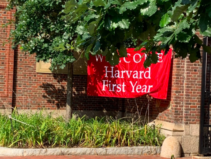 A picture of a red banner saying &quot;Welcome Harvard First Year&quot; in front of a brick wall