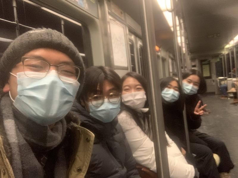 pIcture of Raymond and his friends on an MBTA subway, smiling at the camera.