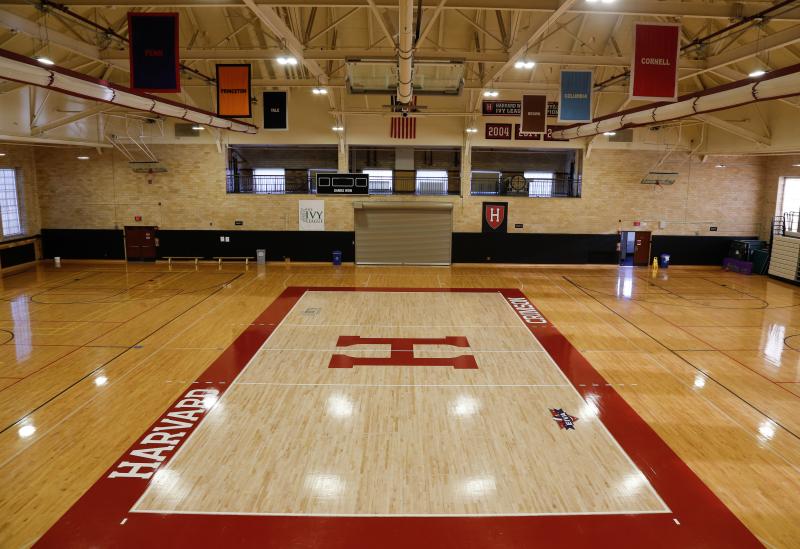 A gymnasium with Harvard decorated flooring