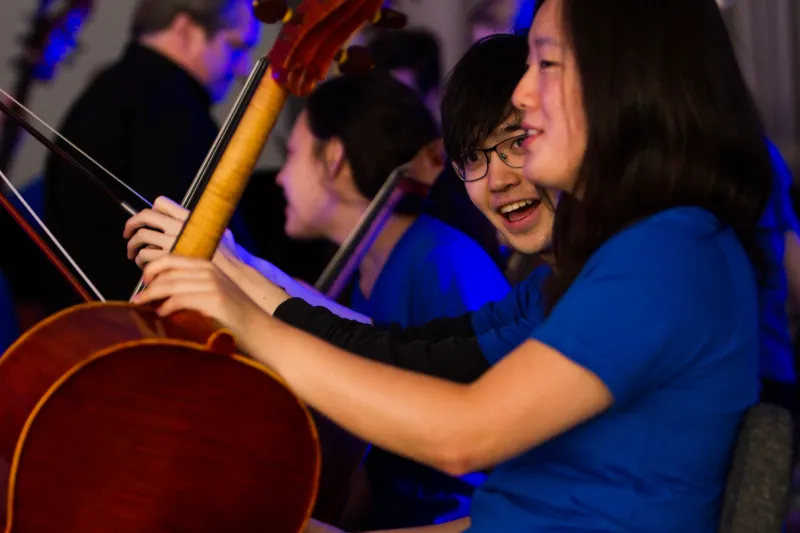 Two cello players talking in orchestra