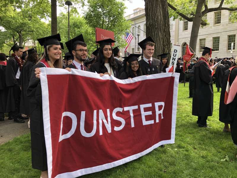 female students holding a dunster banner on commencement day