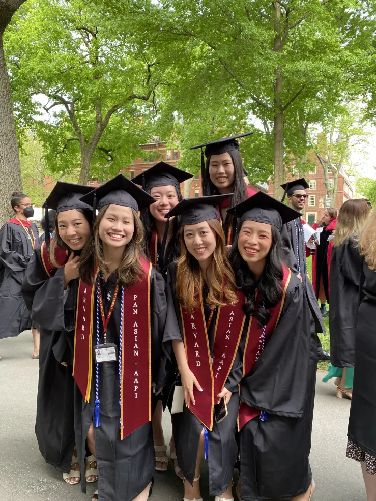 female students in cap and gown on commencement day wearing Pan Asian AAPI around their robe
