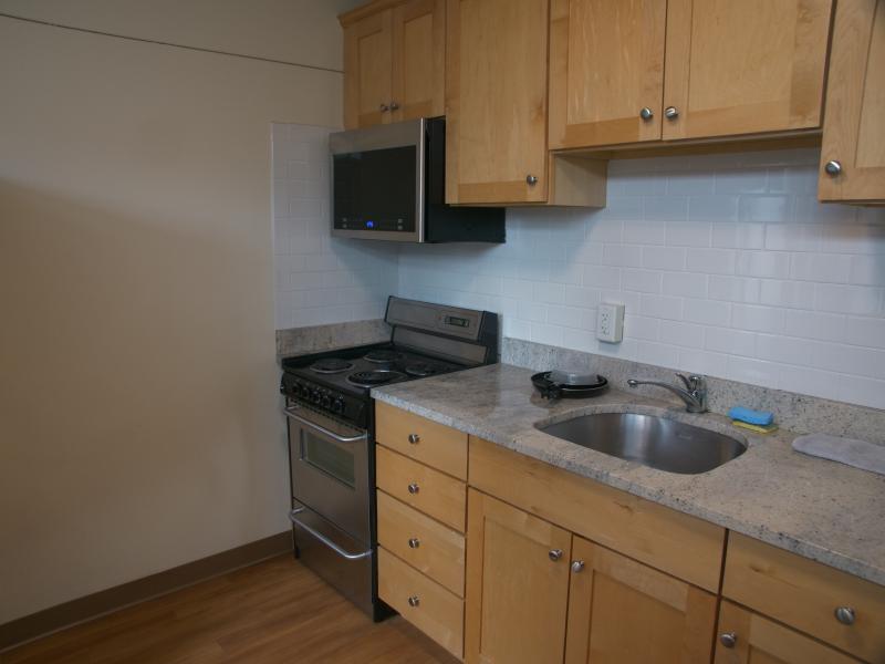 A kitchen equipped with a microwave, stove, sink, and oven