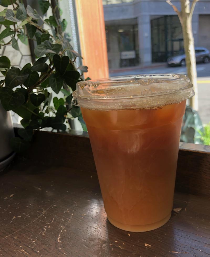 Photo of an iced coffee standing on a brown table