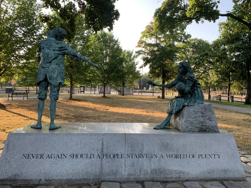 Picture of a statue that reads "Never again should a people starve in a world of plenty."