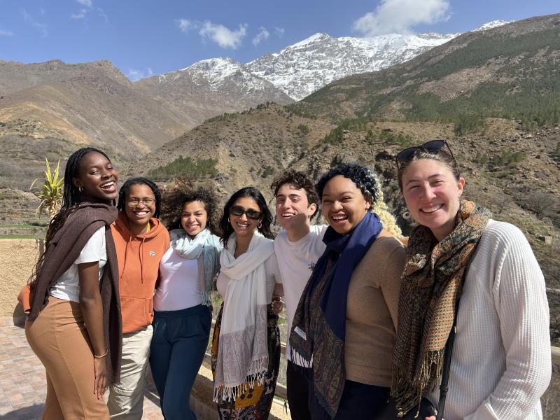 Writer laughing and smiling in front of the Atlas Mountains with six other members of her study abroad group