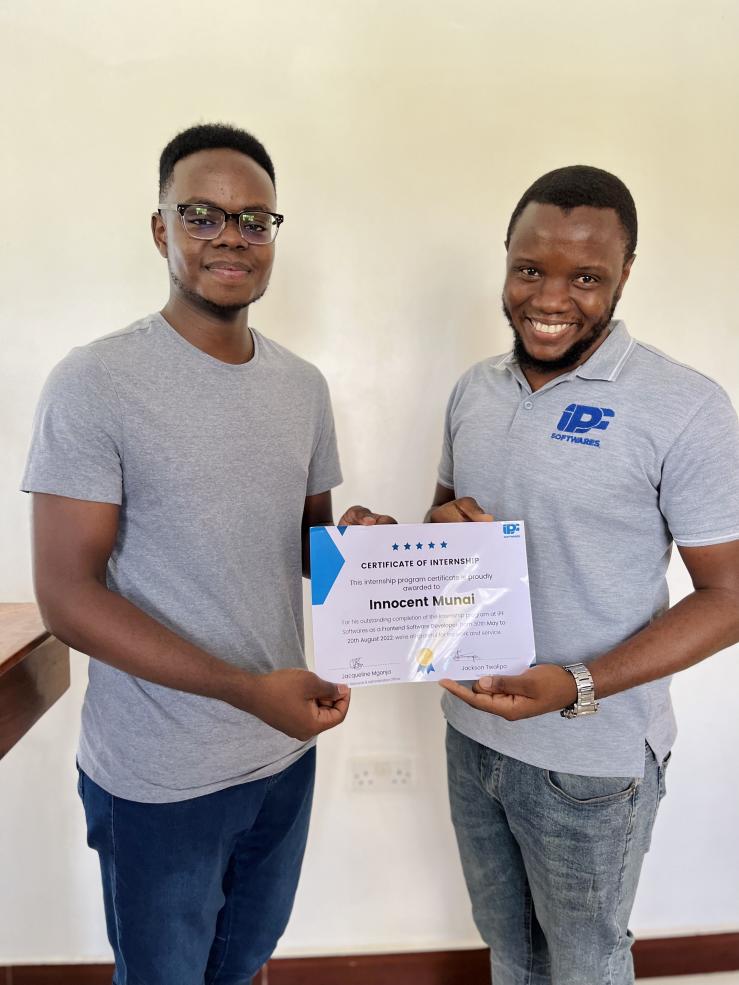 Writer posing with another person after receiving a certificate for outstanding internship completion