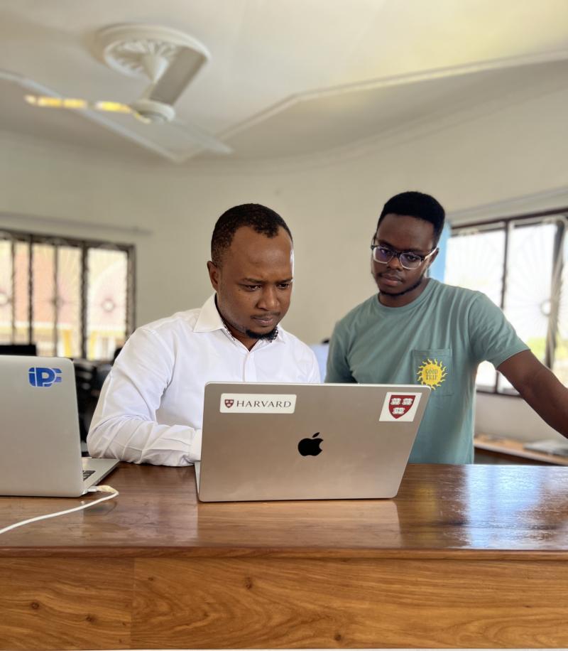 A photograph of Inno and his mentor looking at a laptop