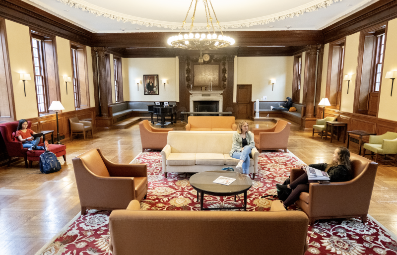 Image of common room, with people sitting on leather chairs around coffee tables