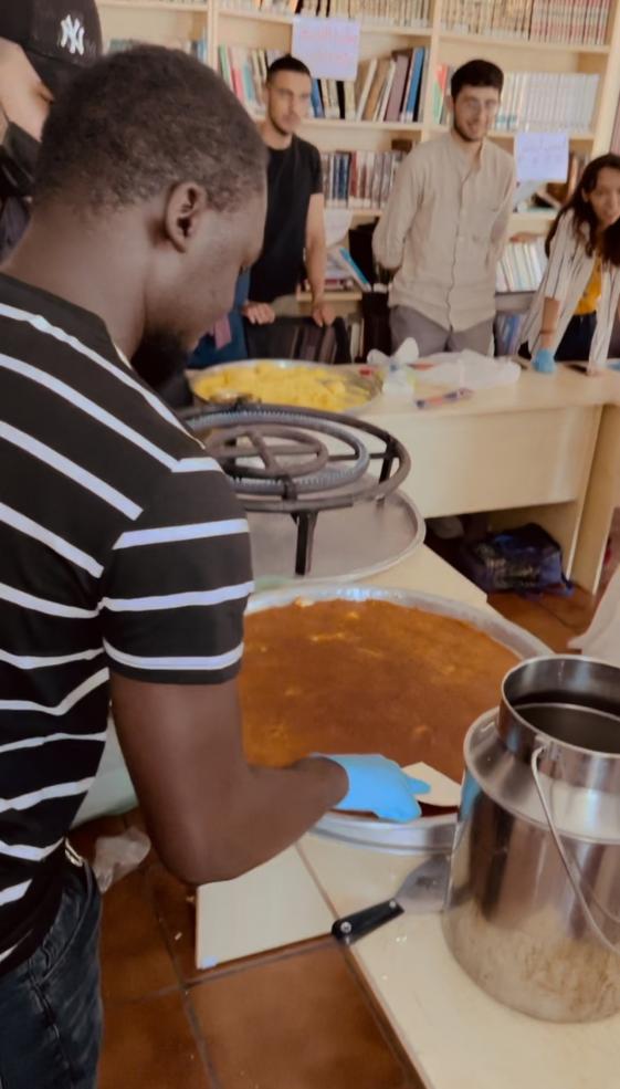 A photo of writer in class making the Middle Eastern dessert “kanafeh”