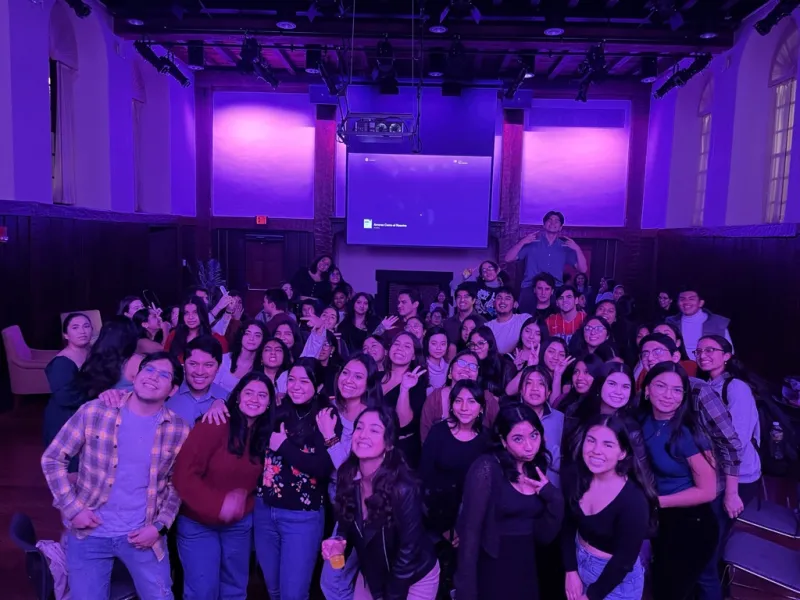 A large group of students smiling for a photograph at a mixer