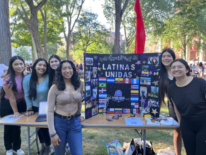 Picture of six students standing in front of a Latinas Unidas poster at activities fair