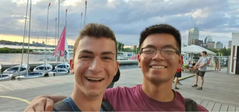 Selfie of Raymond and his friend with sailboats in the background