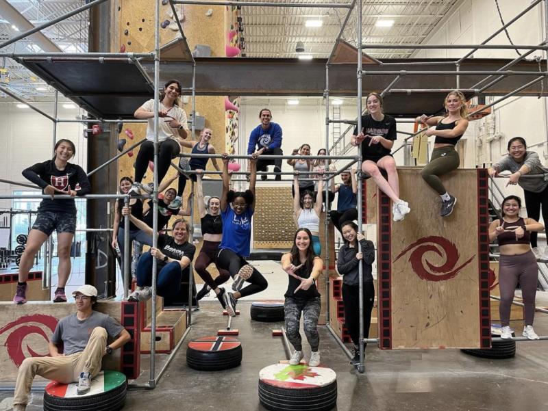 A group of people hanging and posing on a parkour gym