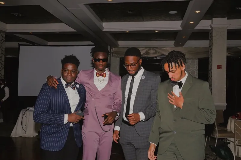 4 guys in suits posing for a photo