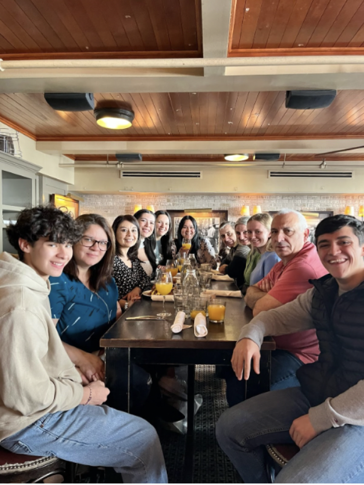 Author posing for a group photo around a dining table with friends and their families