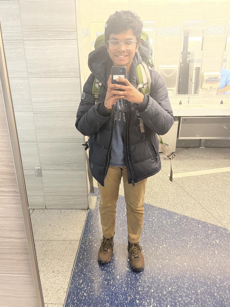 Image of Rafid at the airport wearing an 85L backpack, taking a picture in the mirror.