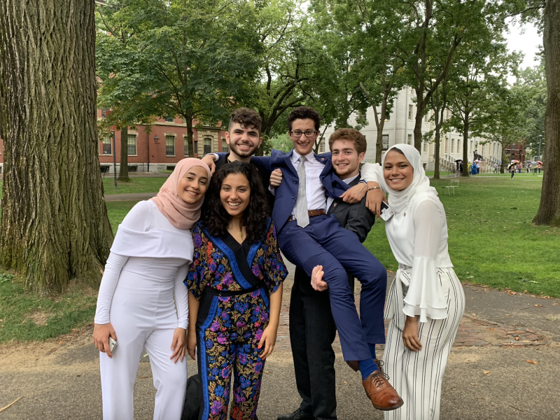 Six friends posing for a photo in Harvard Yard