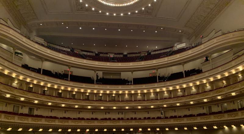 Picture of the balconies and ceiling of the interior of a performance hall lined with lights.