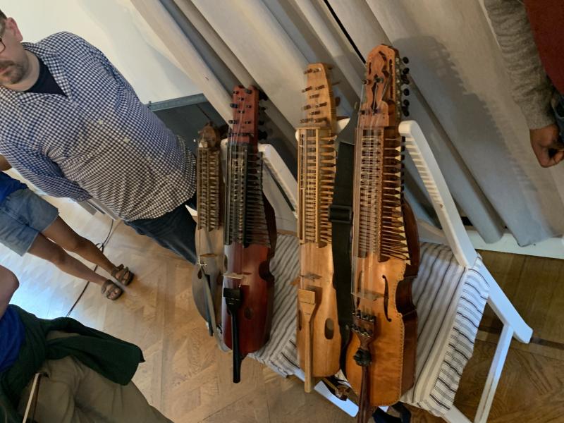 Picture of four string instruments sitting on top of two chairs.