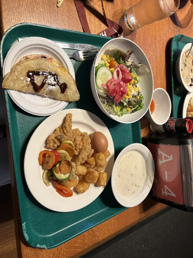 Picture of dining hall food with salad, crepes, and breakfast spread