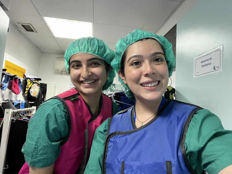 Two girls in scrubs smiling for a picture 