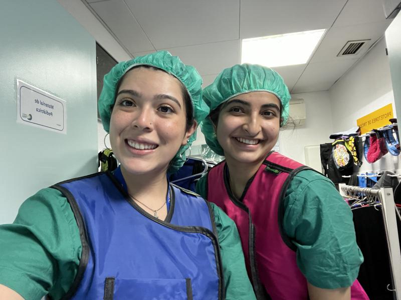 Two girls in scrubs smiling for a picture 