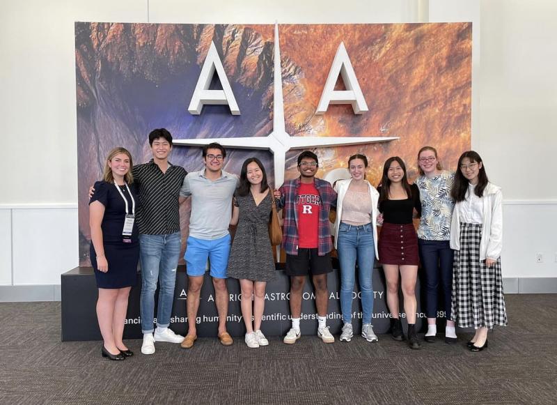 Group of Harvard astrophysics students standing in front of the AAS sign at the 240th meeting of the American Astronomical Society