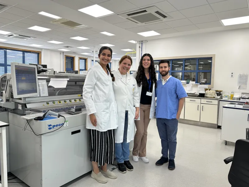 Two doctors and two students smiling in a lab