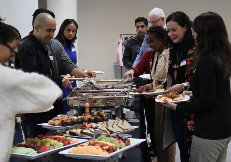 People at the student-alumni brunch grabbing from the brunch menu.  