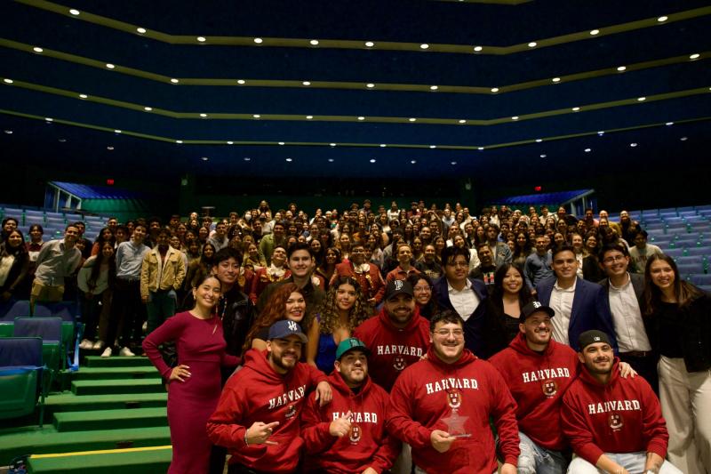 Grupo Frontera band members wearing their Harvard hoodies, alongside RAZA board and RAZA members, and other guests who joined to watch the event. 