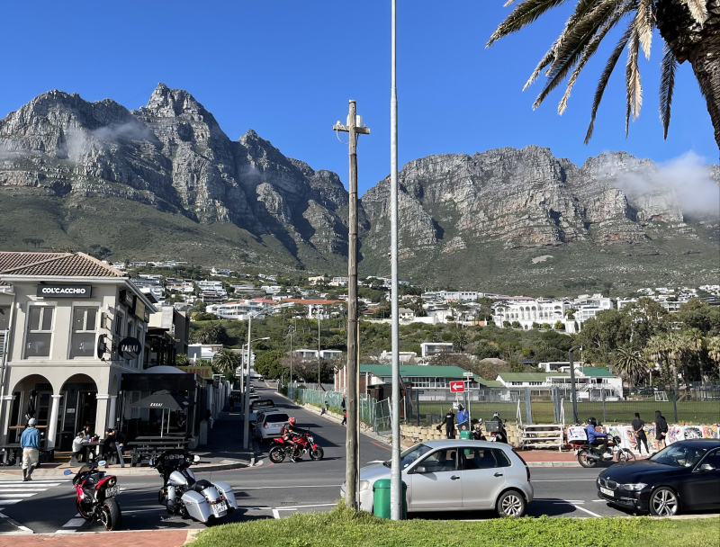 Image of Camp Bay, picture of a car with a road in the background leading to homes and a mountain backdrop