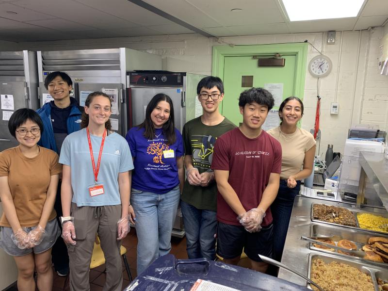 Image of a group of people standing together in the shelter and smiling at the camera.