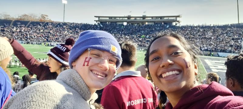 Merlin and Julia smiling in front of Yale&#039;s football field 
