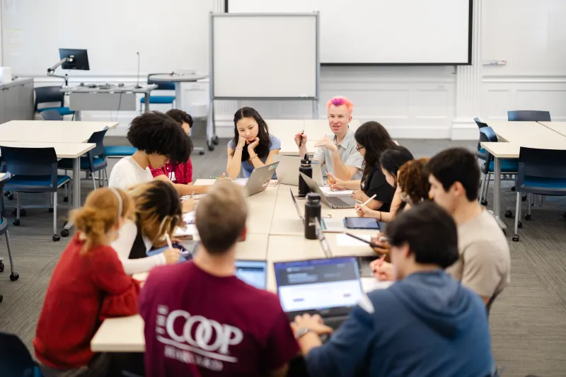 Students sit around a classroom with a professor
