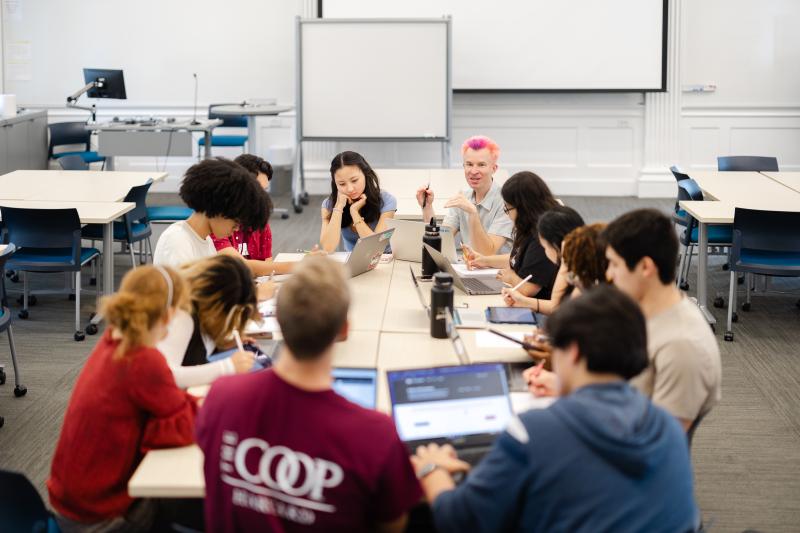 Students sit around a classroom with a professor