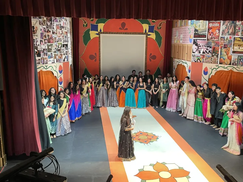 The 100 members of G-Tech, Ghungroo's Tech Team, standing on stage together. 