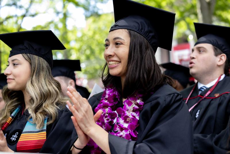 Student giving applause during commencement. 