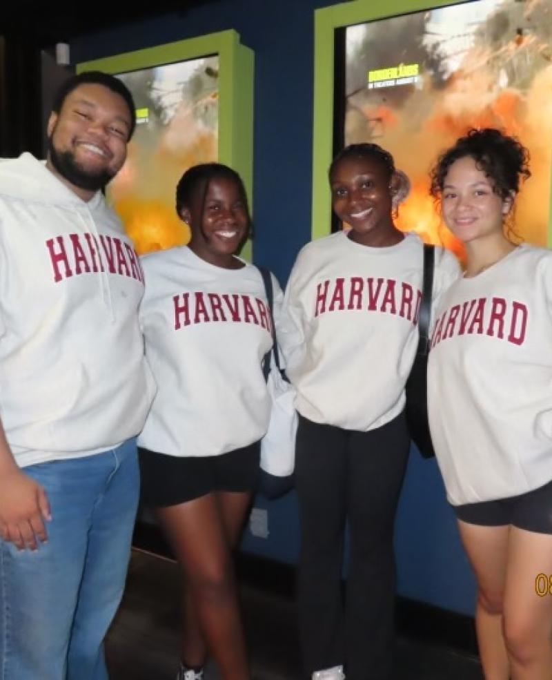 4 people posing in front of a movie poster.