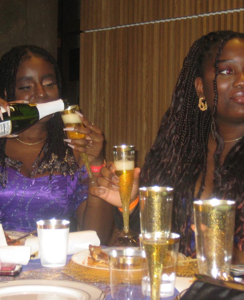 Faith Oji, '27, pouring sparkling cider at a Boston University event