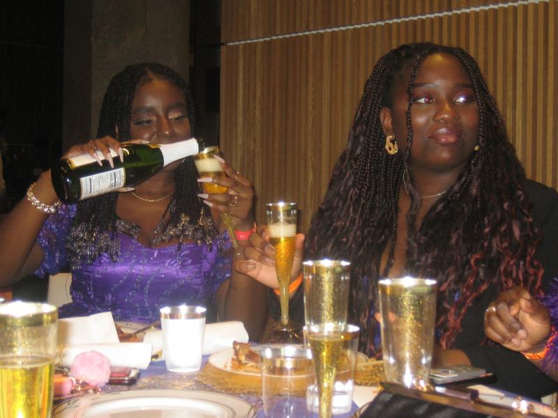 Faith Oji, '27, pouring sparkling cider at a Boston University event