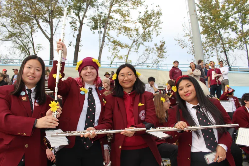 Group of students forming the letter L with their flutes.