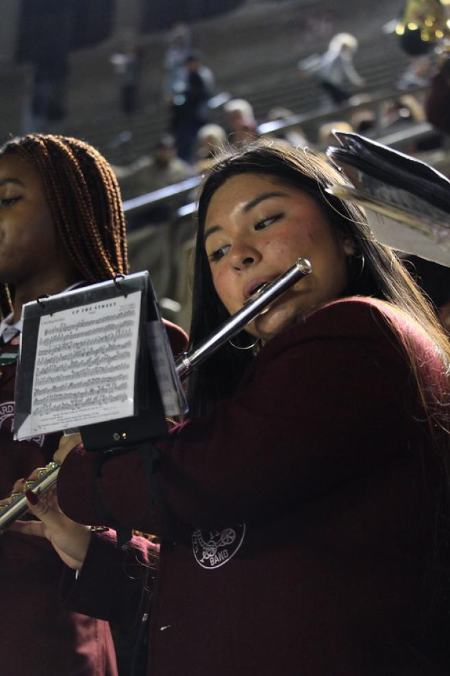 Daisy playing her flute at a football game.
