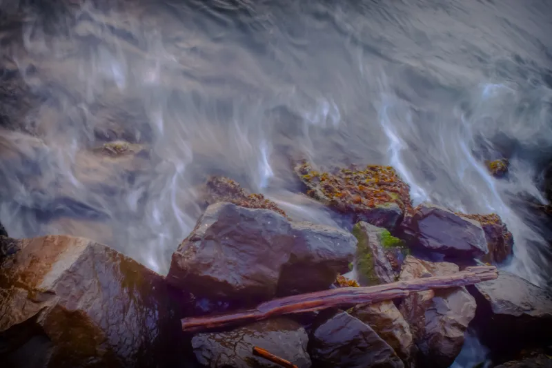 Picture of water rushing over rocks on a rocky shore.