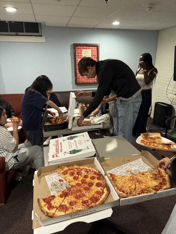 Students sample pizza from several local pizza shops in the Thayer Hall common room.