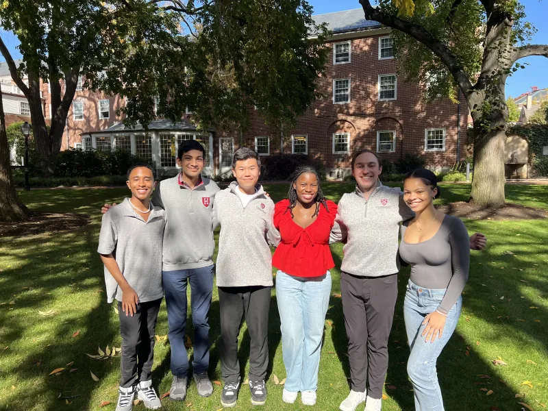 6 people standing in the courtyard of Harvard's Admissions Office building.